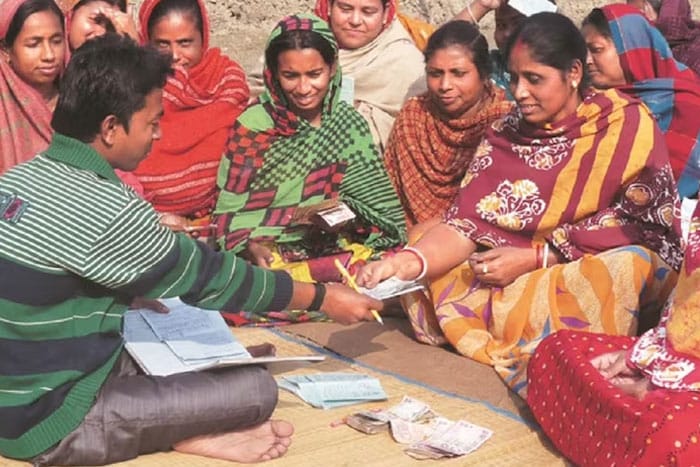 Women Financial Inclusion Business Standard Image of Women Receiving Cash from a Customer Service Rep
